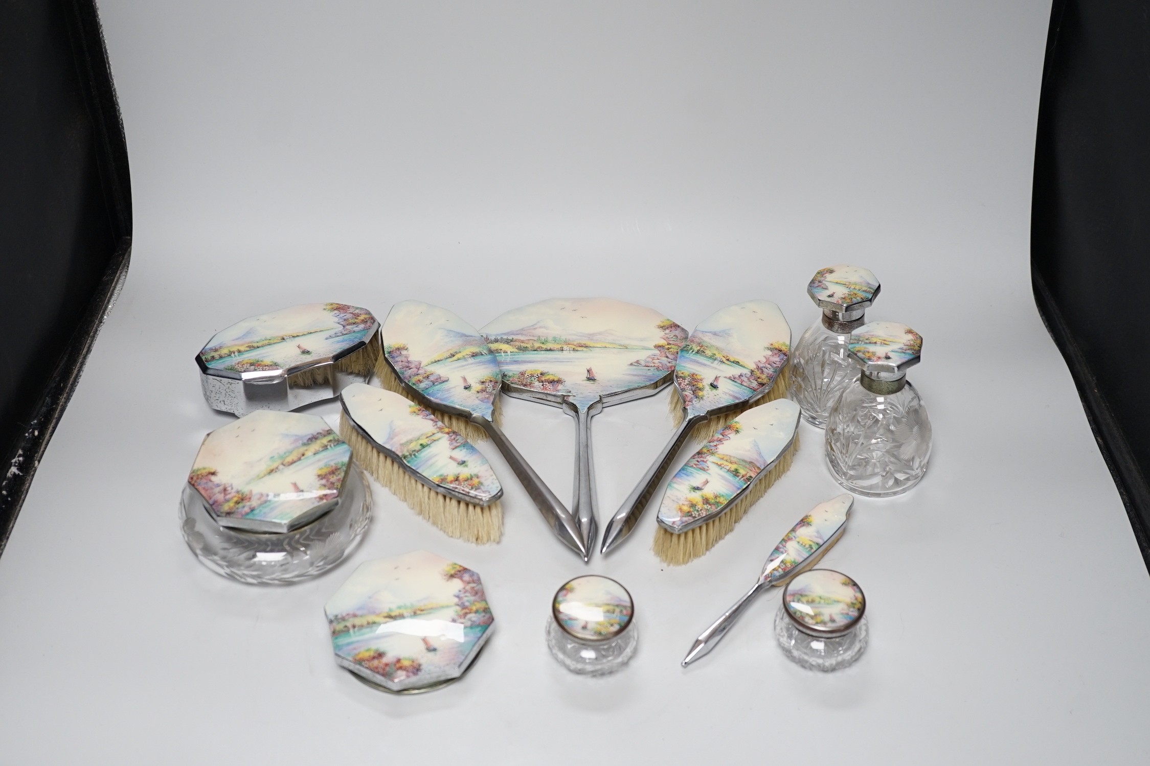 A twelve piece chrome plated and enamel dressing table set